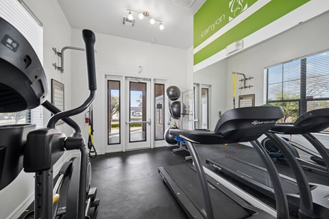 A gym with treadmills and elliptical machines.