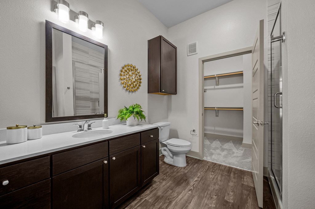 A bathroom with a brown cabinet and a white sink.