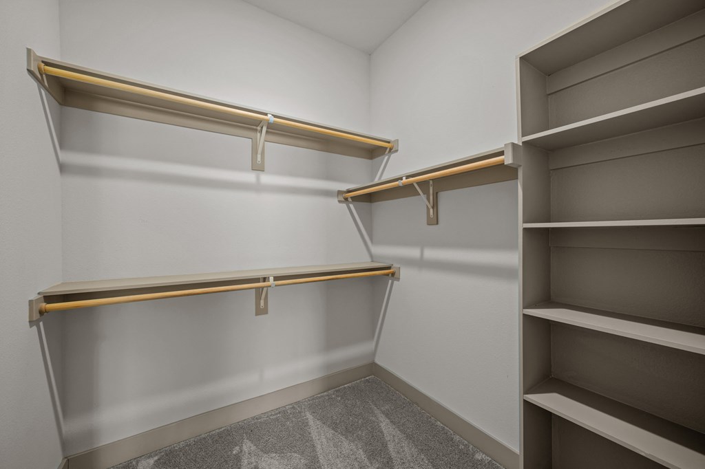 Empty shelves in a room with grey carpet.