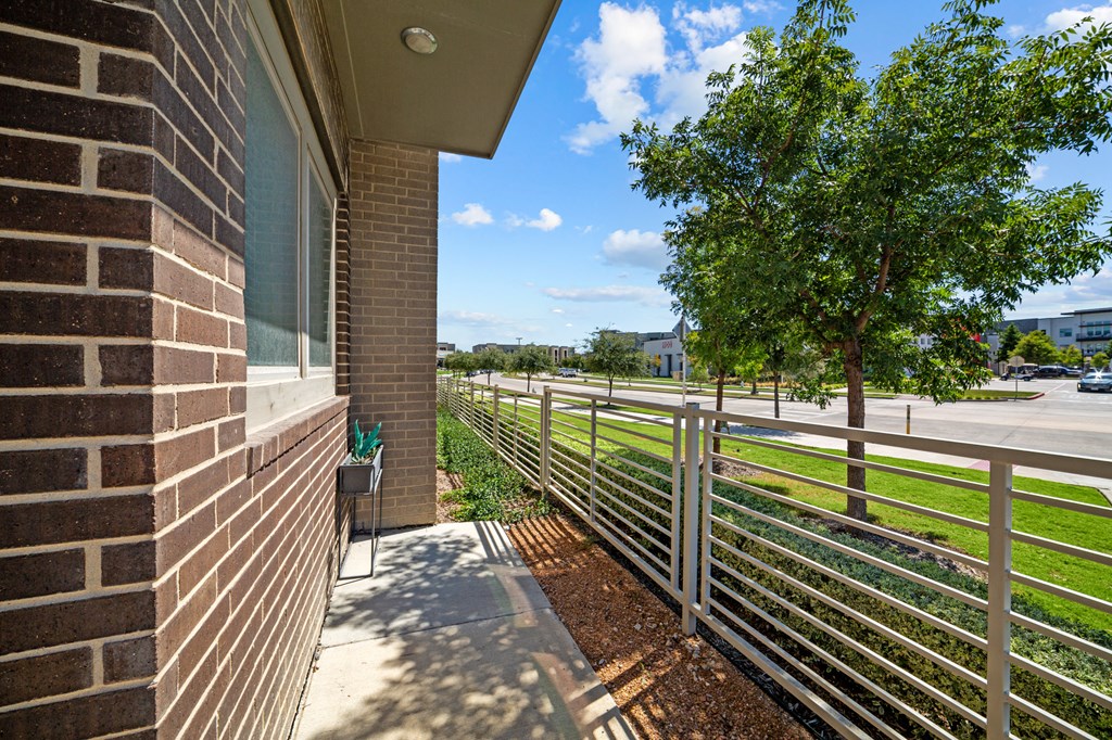 A tree is behind a fence in front of a building.