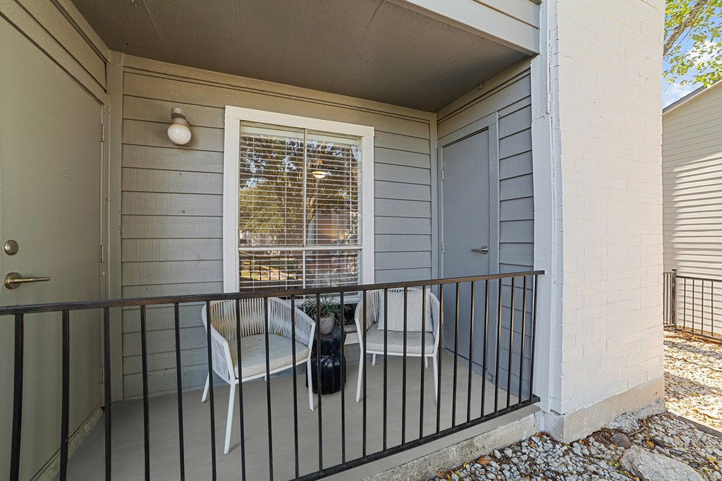A small balcony with a table and chairs.