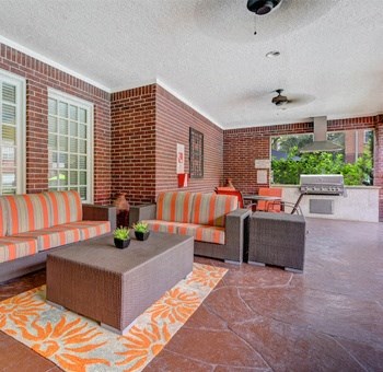 a living room with furniture and a brick wall