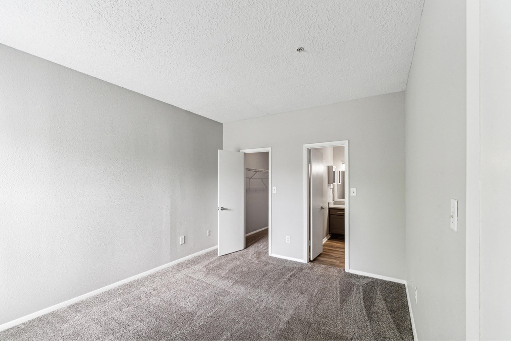 a spacious living room with carpet and white walls