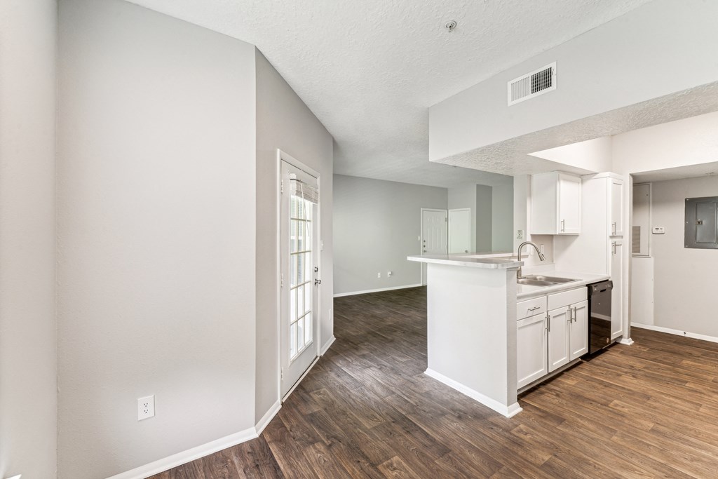 an open kitchen and living room with a hard wood floor
