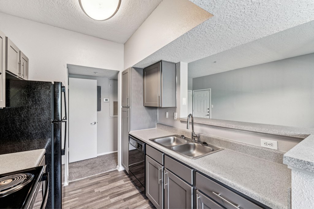 an empty kitchen with stainless steel appliances and a refrigerator