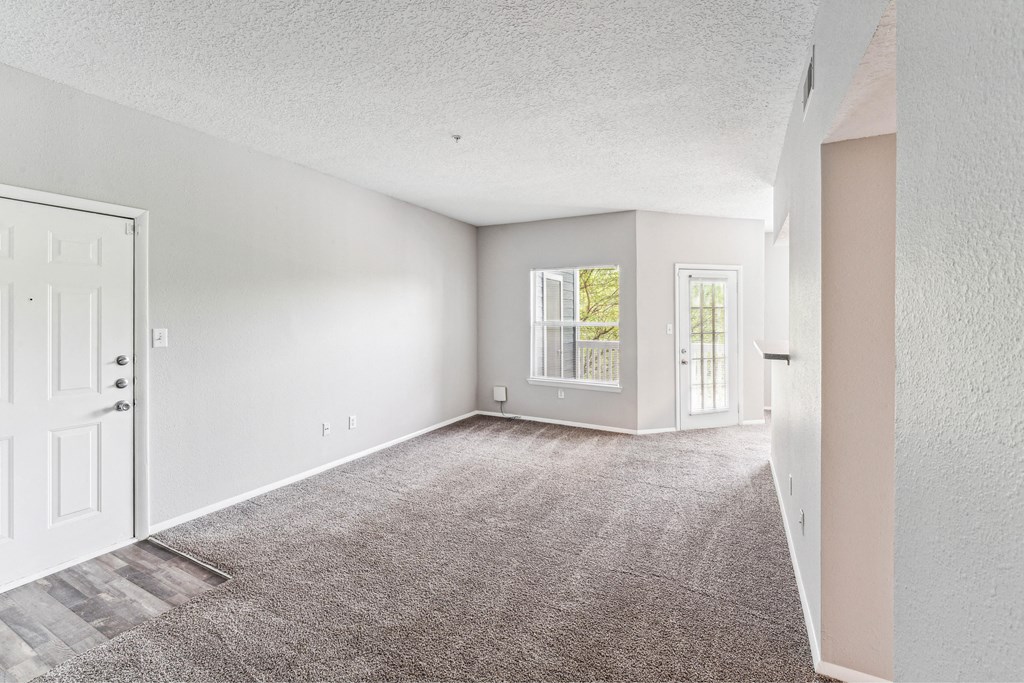 an empty living room with white walls and a white door