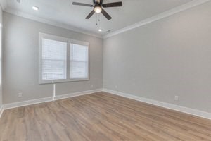 an empty bedroom with a ceiling fan and a window