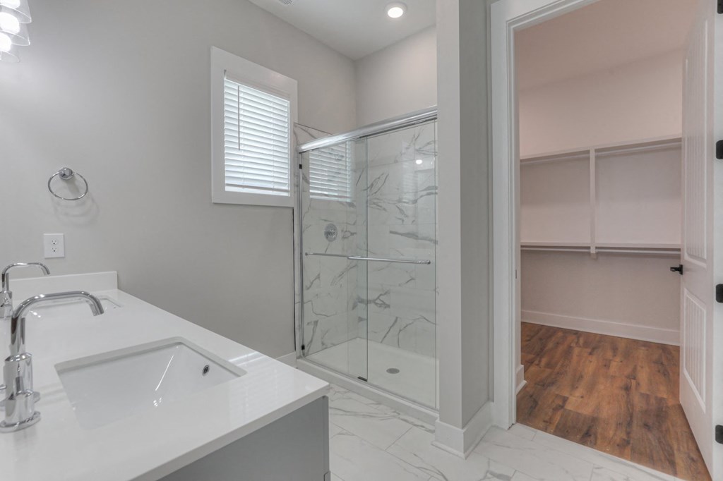 a white bathroom with a shower and a sink