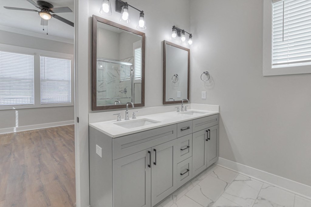 a bathroom with two sinks and two mirrors
