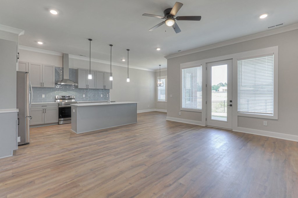an open kitchen and living room with a ceiling fan