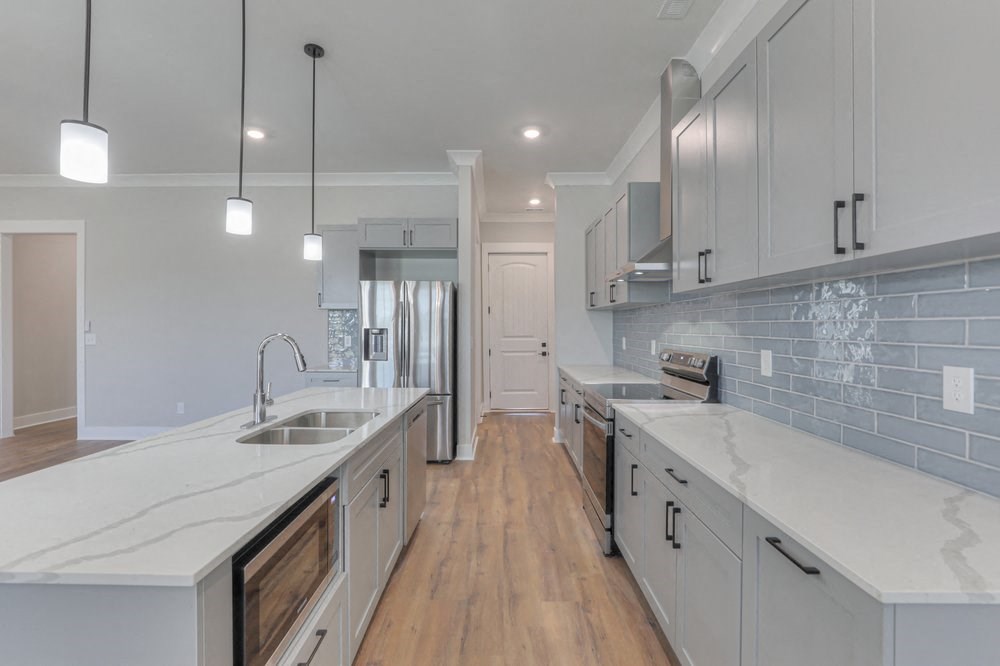 a large kitchen with white counter tops and white cabinets