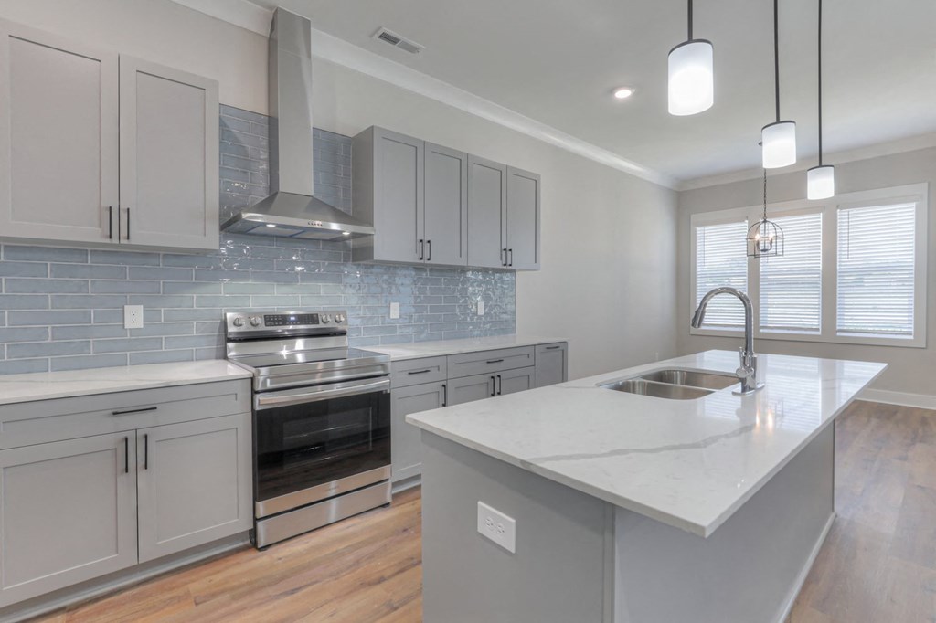 a kitchen with white cabinets and a marble counter top