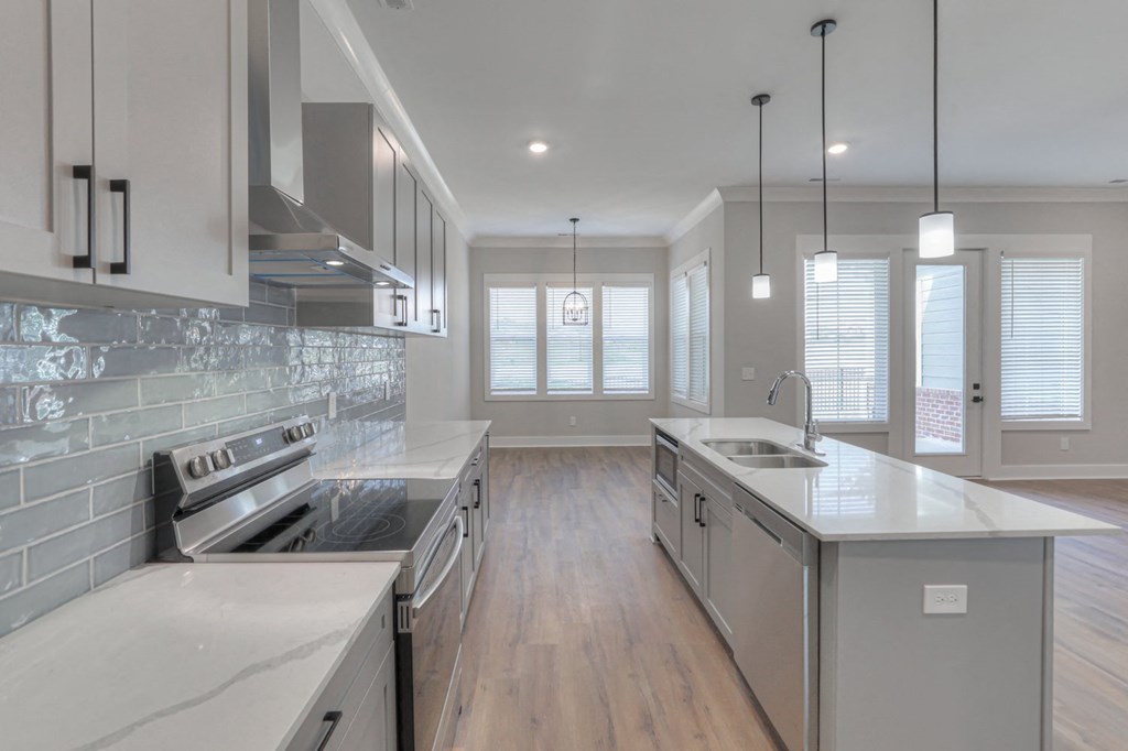 a large kitchen with white counter tops and stainless steel appliances