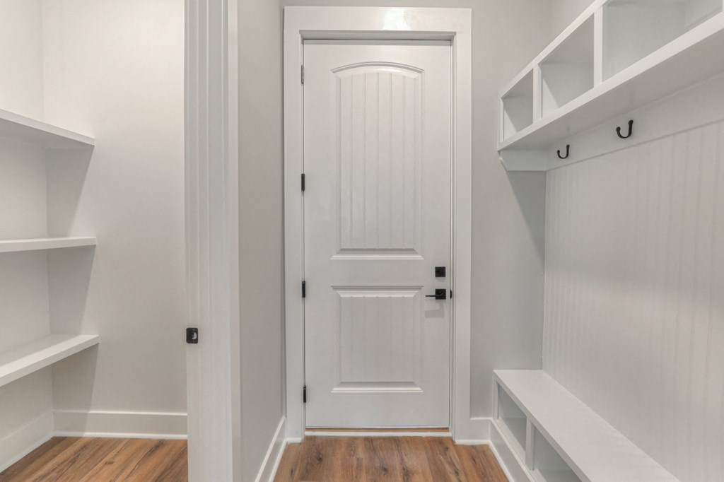 a white closet door in a white room with shelves