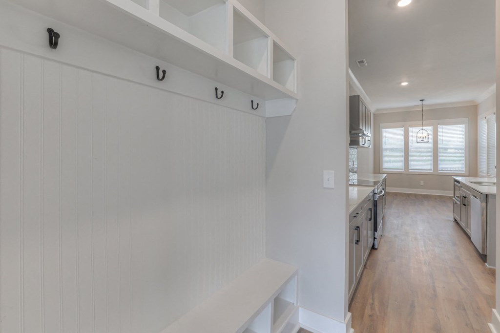 a kitchen with white walls and white cabinets and a white staircase
