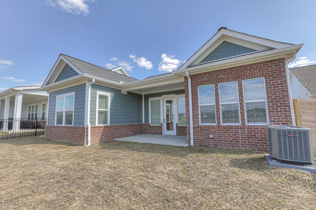 the front of a house with a yard and a trash can