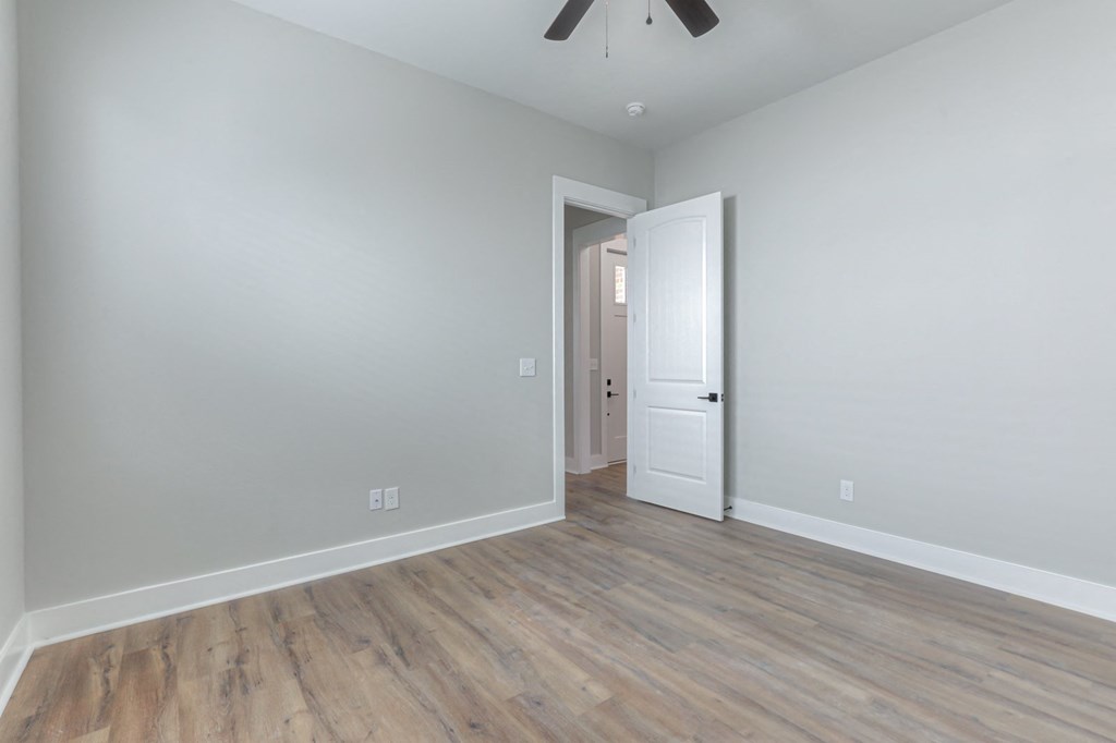 a living room with wood floors and a white door