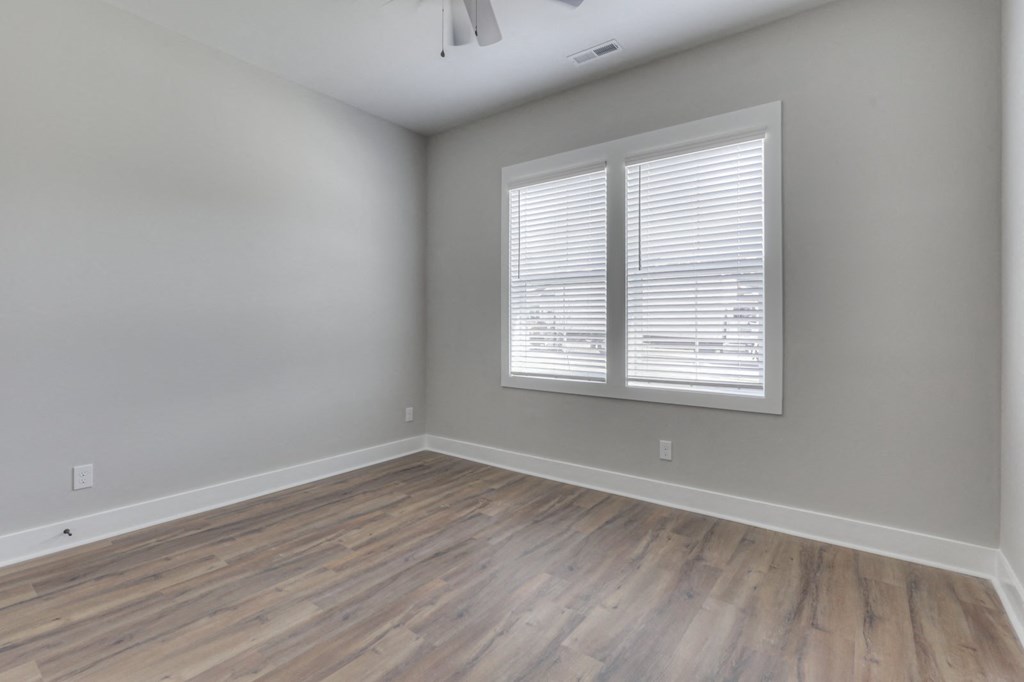 an empty room with wood floors and a window