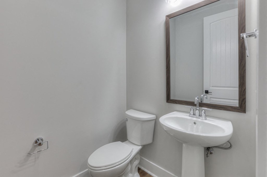 a white bathroom with a sink and toilet and a mirror