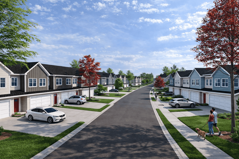 A residential street with houses on both sides and cars parked in the driveways.