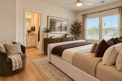 A bedroom with a large bed and a chair.