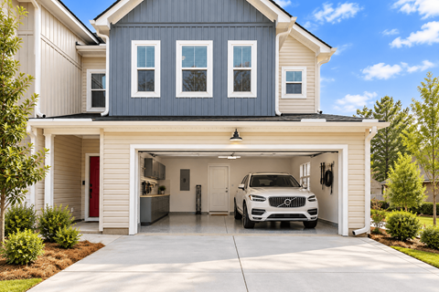A modern house with a garage and a white car inside.