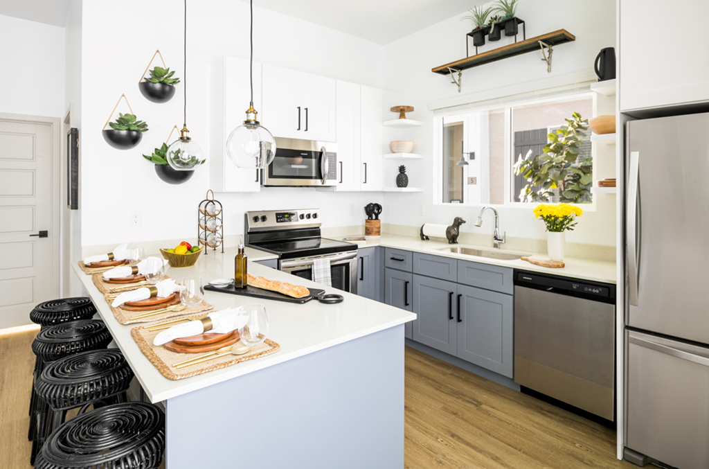 a kitchen with white walls and gray cabinets