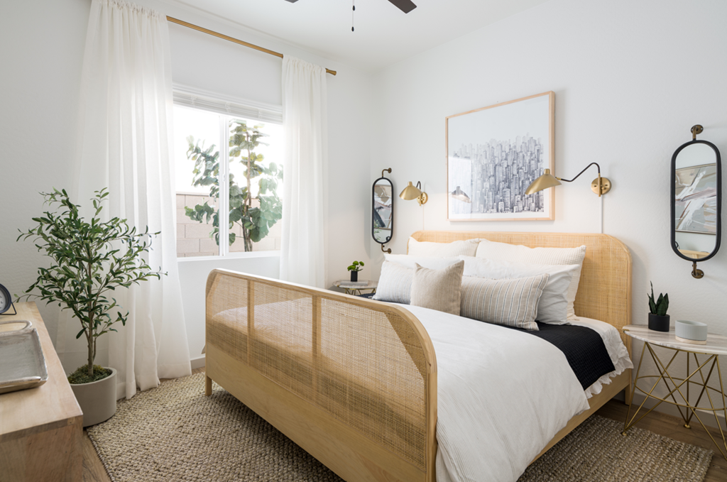 a bedroom with white walls and a wooden bed with white bedding