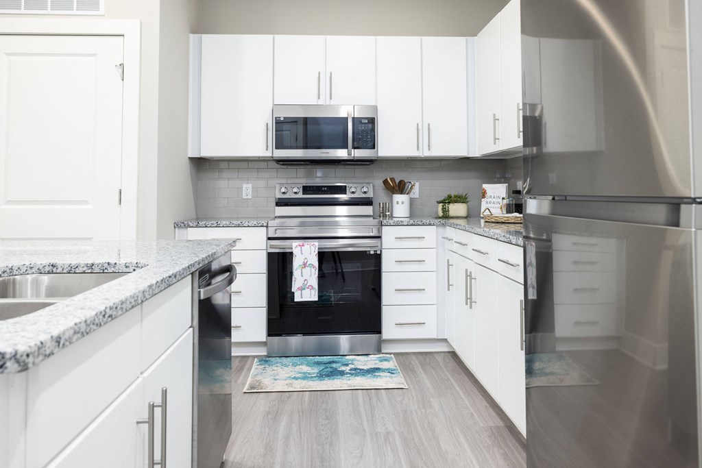 a kitchen with white cabinets and stainless steel appliances