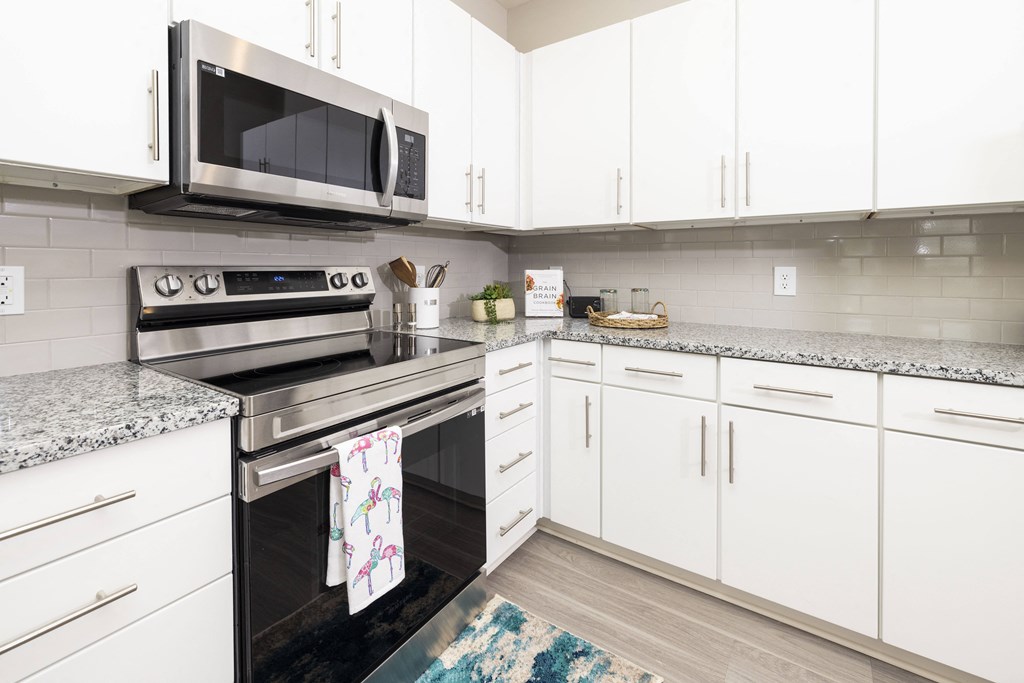 a modern kitchen with white cabinets and stainless steel appliances
