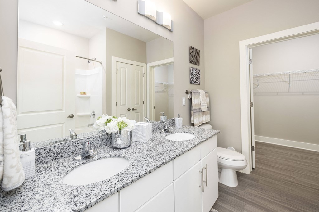 a white bathroom with two sinks and a mirror
