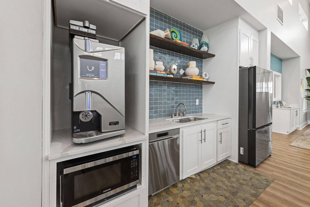 a kitchen with white cabinets and stainless steel appliances and a refrigerator