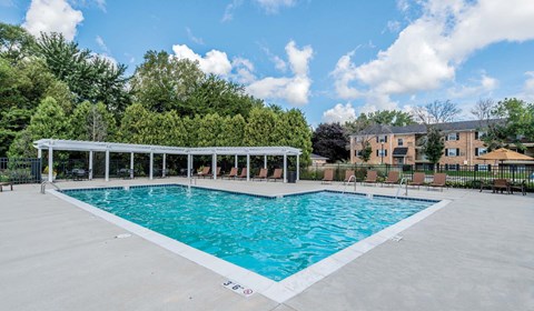 A large outdoor swimming pool with a white fence around it.