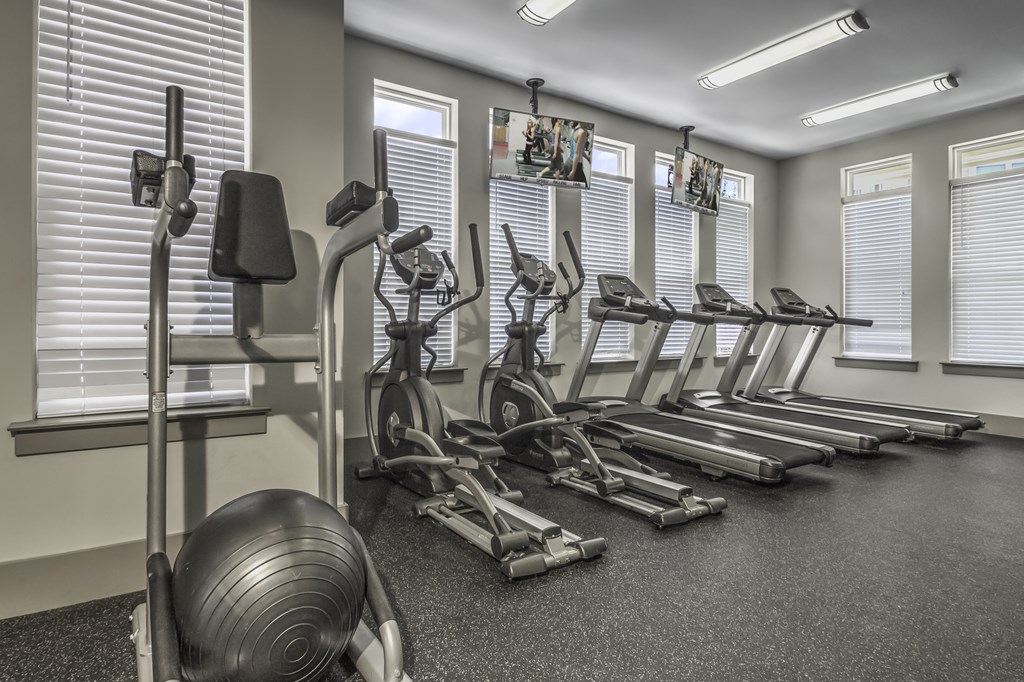 a gym with cardio machines and weights on the floor