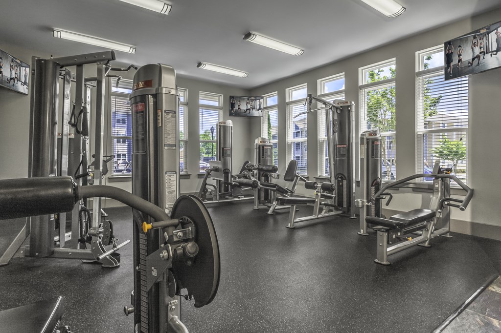 a gym with exercise equipment and windows in a building