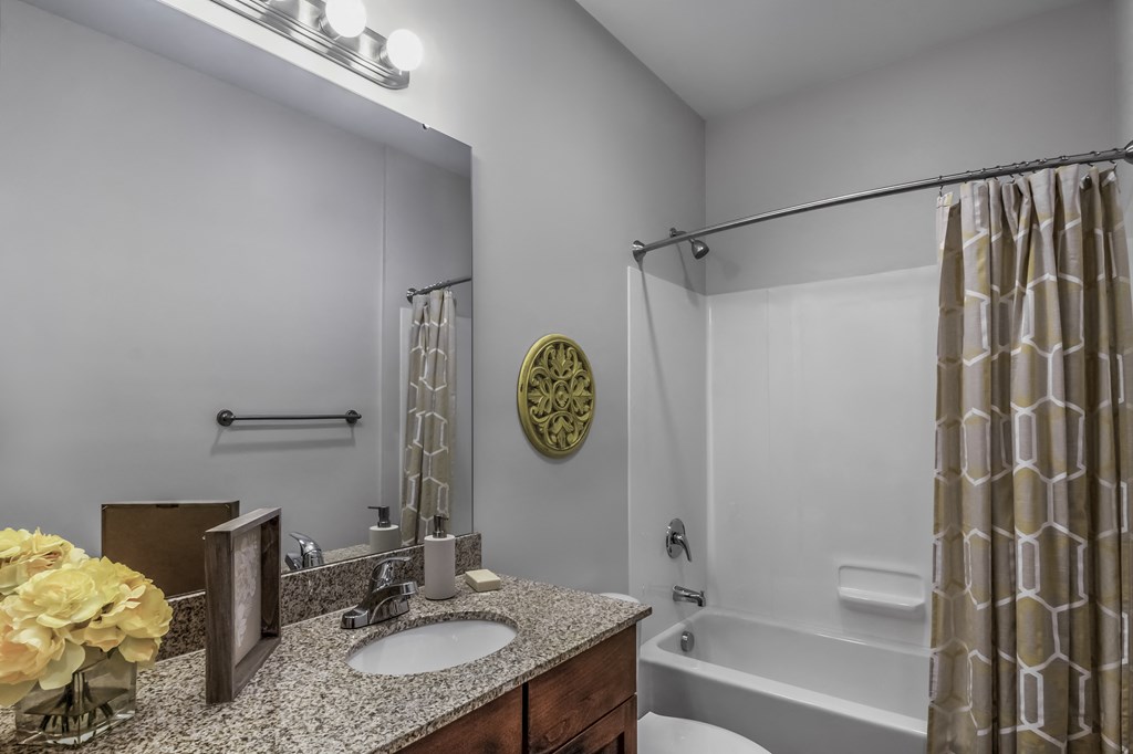 a bathroom with a shower and a sink and a mirror