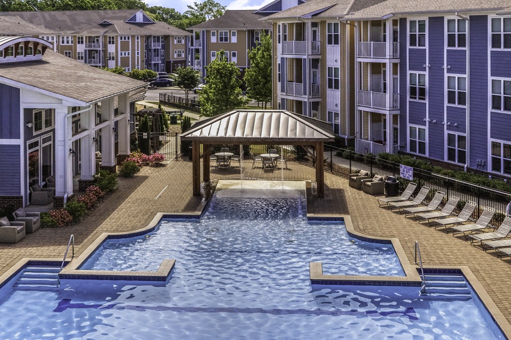 an aerial view of a large swimming pool in front of an apartment building