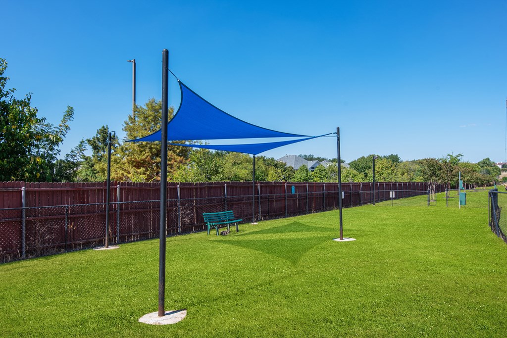 a park with a blue canopy and a bench