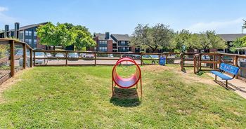 a playground with a seesaw in the middle of a grassy area