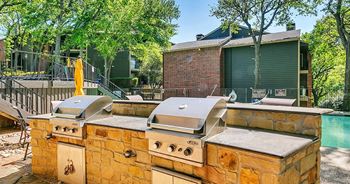 a backyard with two barbecue grills and a pool in the background