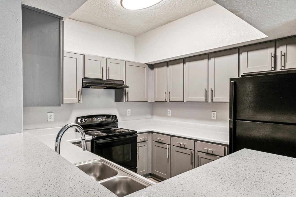 a kitchen with black appliances and white counter tops