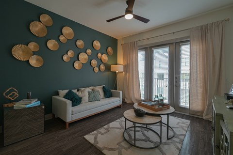 A living room with a white couch and a ceiling fan.