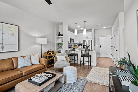 A modern living room with a brown leather couch and a coffee table in the center.