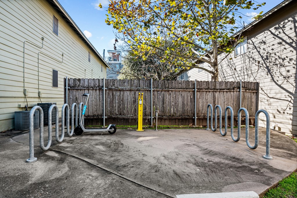 the back yard of a house with a bike rack and a fence