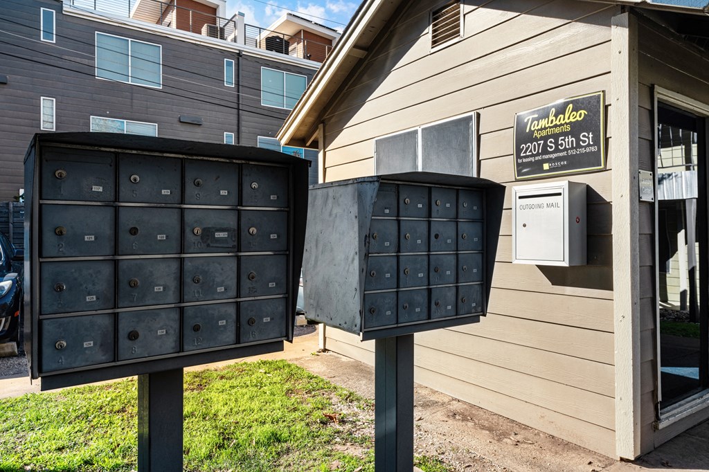two mailboxes in front of a house with a mail truck