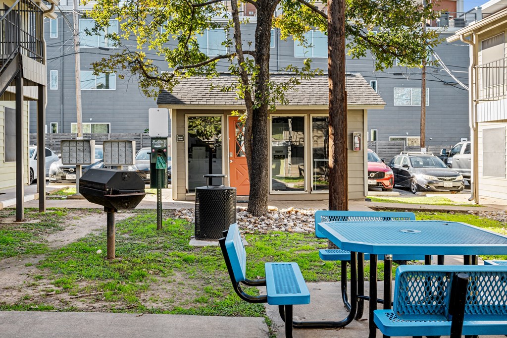 a picnic area with tables and chairs in front of a building