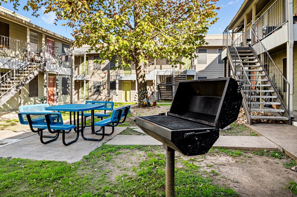 our apartments have a backyard with a grill and a picnic table