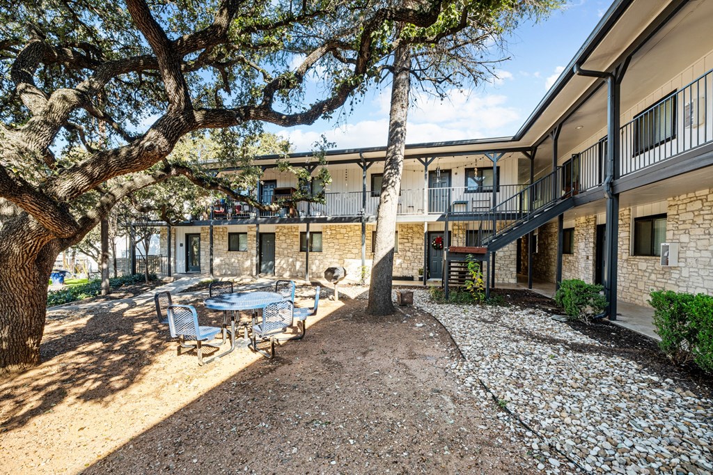 a courtyard with a table and chairs in front of a building
