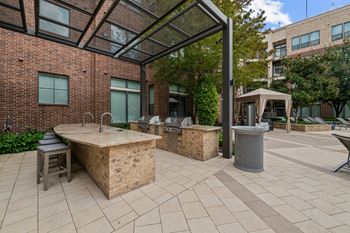 A patio with a table and chairs is surrounded by a brick building.
