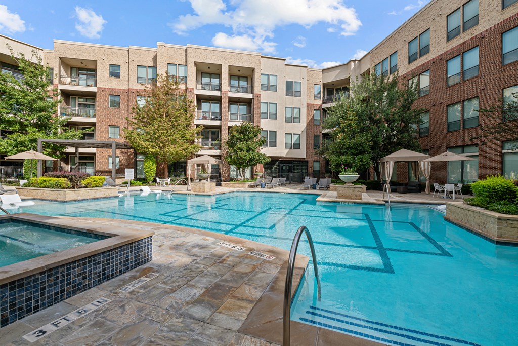 a swimming pool with an apartment building in the background